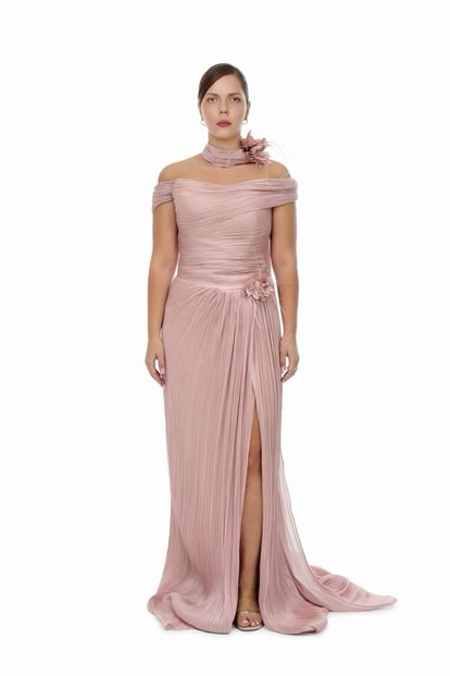 فستان سهرة بمقاسات كبيرة، بلون وردي فاتح، بياقة واسعة، وتفاصيل شال طويل، وتطريزات زهرية، وكسرات 